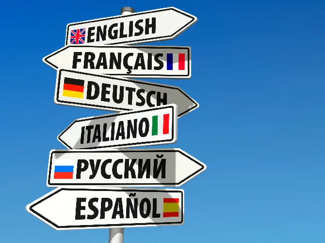 Kierunkowskaz z tabliczkami z nazwami języków obcych