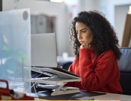 Kobieta siedząca przed laptopem przy biurko